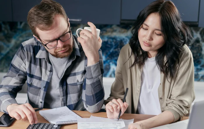 Couple reviewing home loan documents while considering mortgage forbearance due to rising living costs