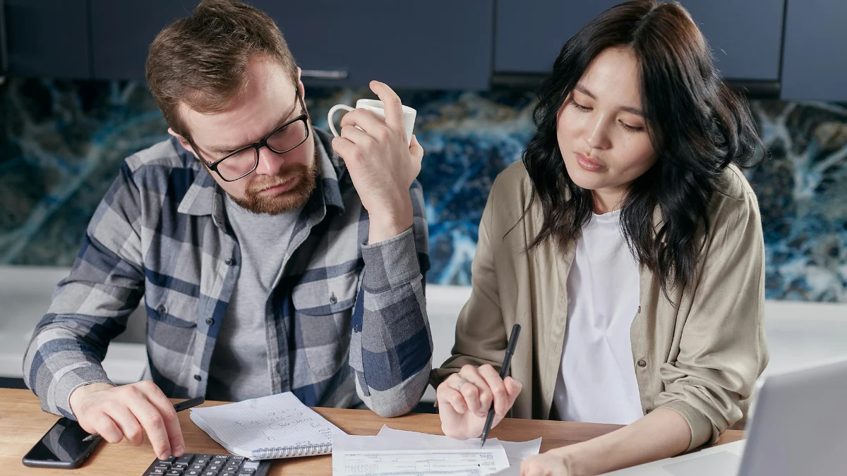 Couple reviewing home loan documents while considering mortgage forbearance due to rising living costs