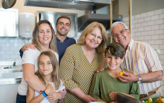 Family discussing finances at kitchen table while considering mortgage forbearance for temporary payment relief