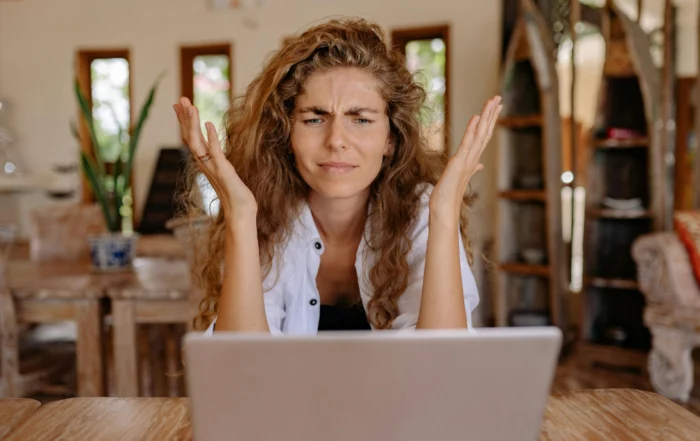 Homeowner using laptop to request mortgage forbearance and pause mortgage payments during financial difficulty